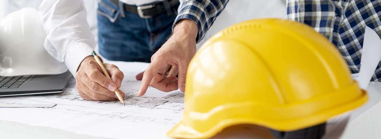 “Architekt-Bauplanung” Architekten besprechen eine Bauzeichnung mit Bauhelm auf dem Tisch